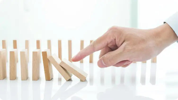 Pointed finger knocks over a row of dominoes