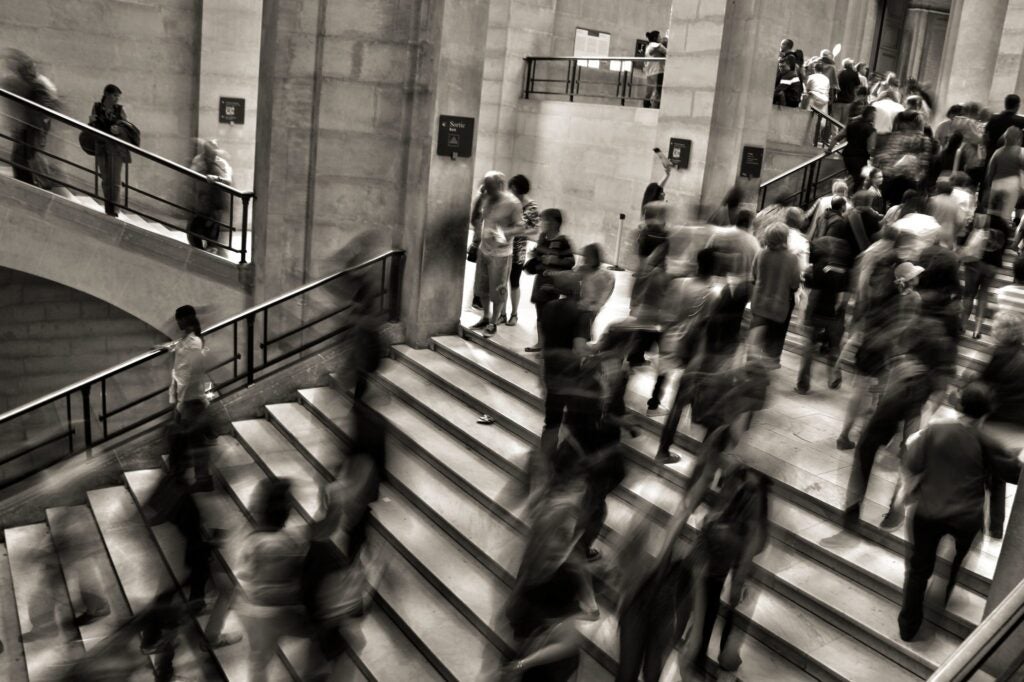 Black and white photo of crowded stairway with faces blurred