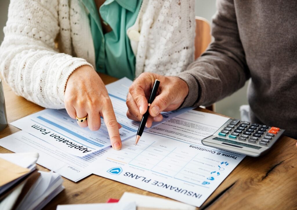 two people look at medical insurance forms and paperwork together