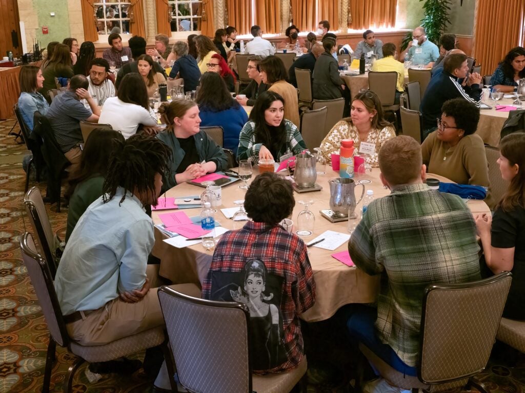 A group of Roybal Retreat attendees discuss how to promote equity in their work as they sit around a table.