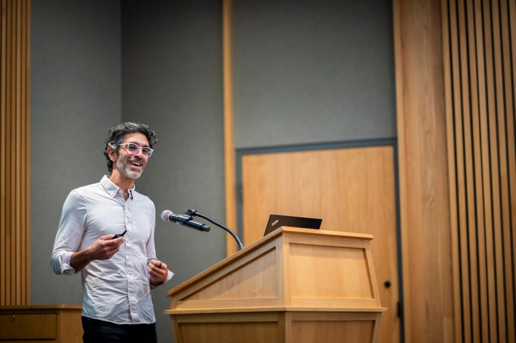 ziad obermeyer stands in front of a podium at CHIBE's 2023 symposium