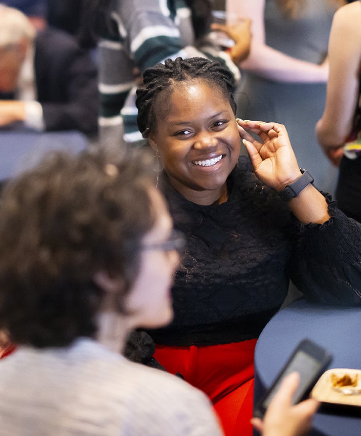 Close crop of two women in discussion at a conference table, one out of focus